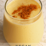 A thick, golden drink garnished with fresh spices on top