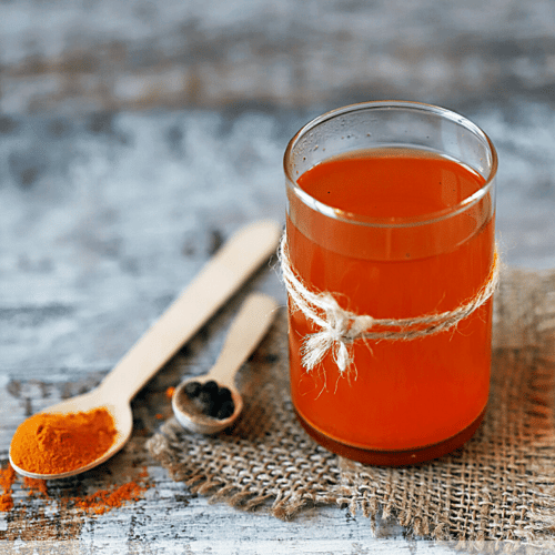 a glass of delicious and cooling turmeric tea with a deep orange color