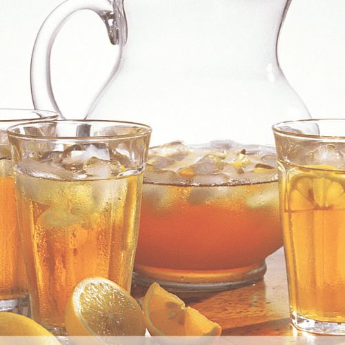 A large pitcher of turmeric vodka tea cooler with glasses